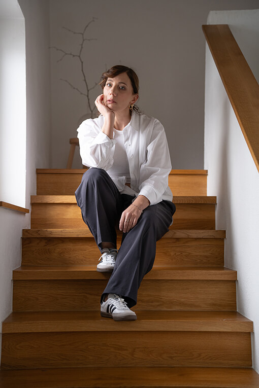 Kommunikationsspezialistin Schauspielerin Simone Wagner auf Treppe sitzend